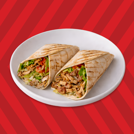 Chicken shawarma wrap cut in half with fresh veggies and sauce
