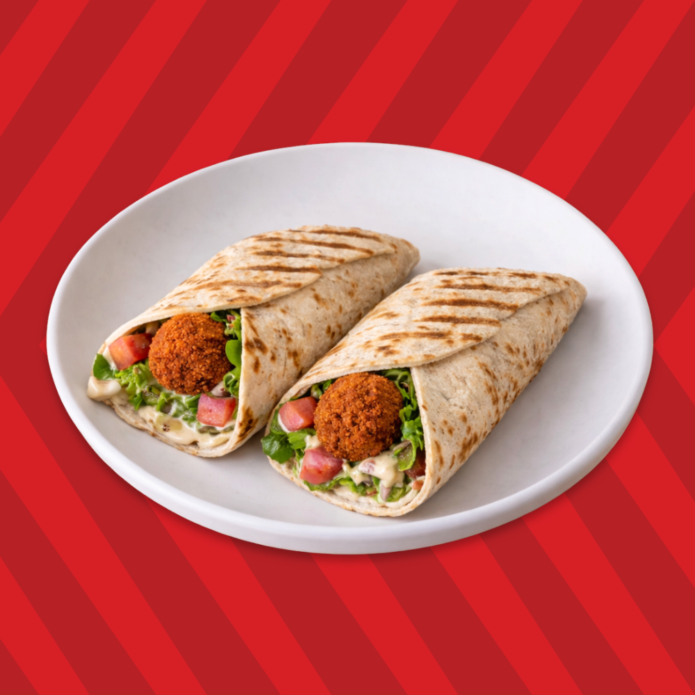 Falafel wrap cut in half with salad and creamy sauce